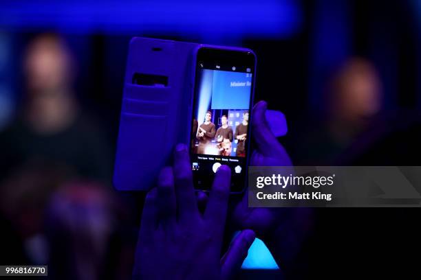 Fan takes a photo of players on stage during a New South Wales Blues public reception after winning the 2018 State of Origin series at The Star on...