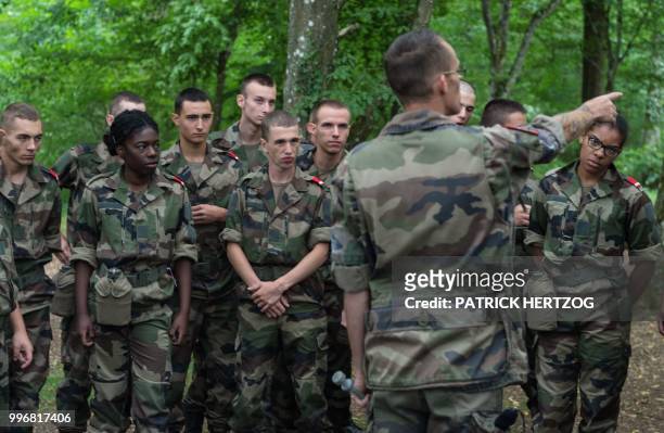 An instructor gives advices to young recruits of the voluntary military service as they train to install a bivouac in a woodland on July 10 near...