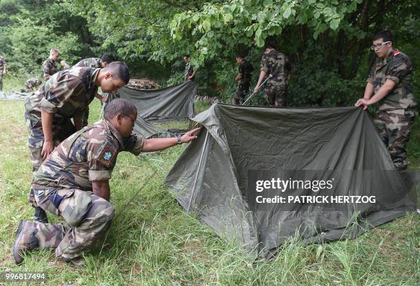 An instructor gives advices to young recruits of the voluntary military service as they train to install a bivouac in a woodland on July 10 near...