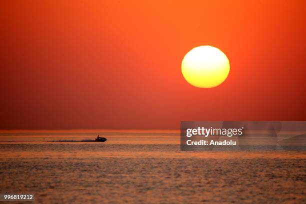 Man rides a jet ski through coastal side during a sunset at the second public beach of Lake Van, in Van, Turkey on July 12, 2018.