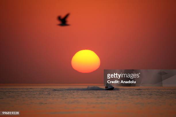 Man rides a jet ski through coastal side during a sunset at the second public beach of Lake Van, in Van, Turkey on July 12, 2018.