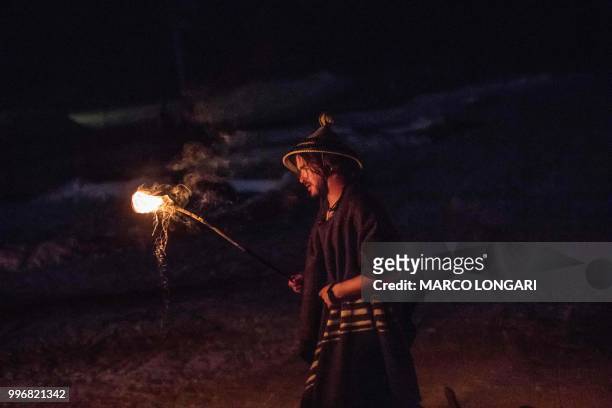 Ski instructor dressed in traditional Basotho attire descends during a torchlight procession from the top of the main 1km slope at the Lesotho...