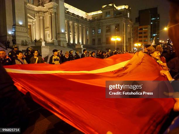 Giant Peruvian flag carried by the crowd when citizens take to the streets of Lima and occupy the San Martin square and Justice Palace in reaction to...