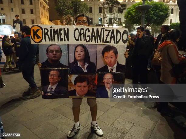 Racketeering poster with Peruvian last presidents and main politics pictures held by a man when citizens take to the streets of Lima and occupy the...