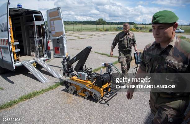 French army legionnaires get ready to practice a mine-clearing exercice with a bomb disposal robot in Saint-Christol, southern France, on June 12,...