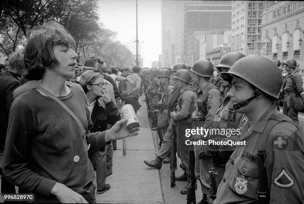 During the Democratic National Convention, a line of demontrators face a line of National Guardsmen across the street from the Hilton Hotel at Grant...