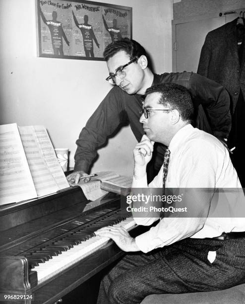 View of American musical theater composer Jerry Bock and lyricist Sheldon Harnick as they look over a musical score at a piano, New York, New York,...