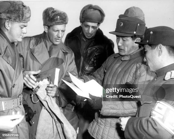 Members of the US Army deliver POW's mail to North Korean military policemen, Panmunjom, Korea, 1952. The mail, from North Korean and Chinese...