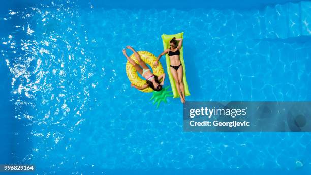 mother and daughter in the pool - pool raft imagens e fotografias de stock