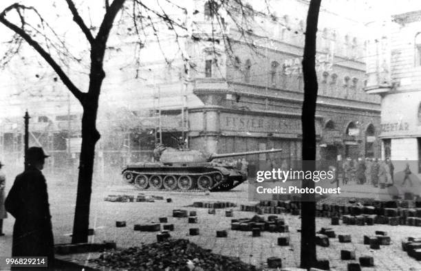 View of Russian Army tank as it patrols past pedestrians during the Hungarian Revolution, Budapest, Hungary, November 1956. The original caption...