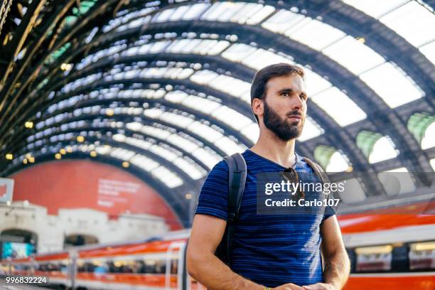 mooie jonge man die wachten op de trein - carlo107 stockfoto's en -beelden