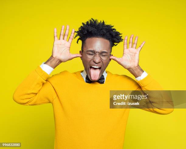 funny portrait of nerdy young man sticking out tongue - izusek stock pictures, royalty-free photos & images