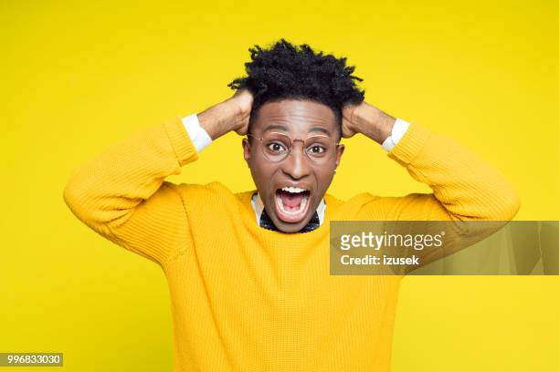 portrait of frustrated geeky young man holding hands in hair - izusek stock pictures, royalty-free photos & images