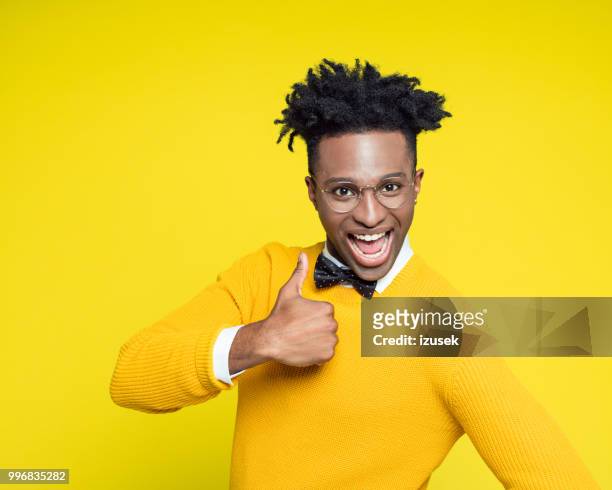 lustige porträt von glücklich nerdy junger mann mit daumen - izusek stock-fotos und bilder