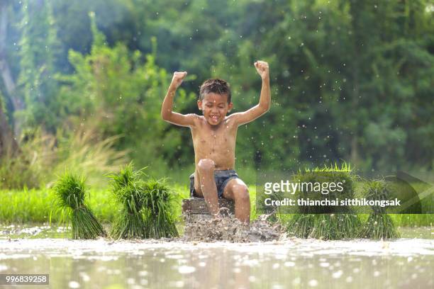 naughty kid enjoy playing mud - province de chonburi photos et images de collection
