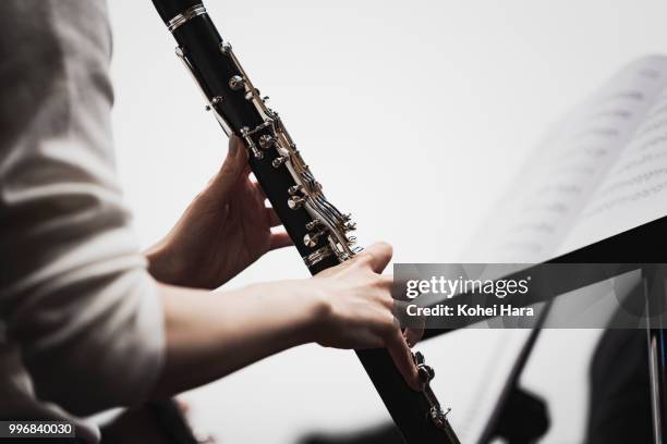 woman playing a clarinet at concert hall in rehearsal - klarinette stock-fotos und bilder