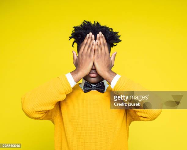 portrait nerdy young man covering eyes with hands - izusek stock pictures, royalty-free photos & images