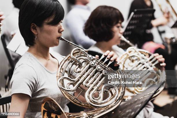 Women playing a horn at concert hall in rehearsal