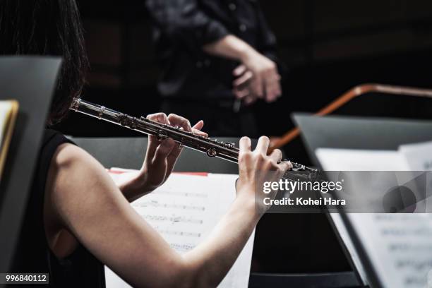 orchestra playing musical instruments at concert hall - classical orchestral music stock pictures, royalty-free photos & images