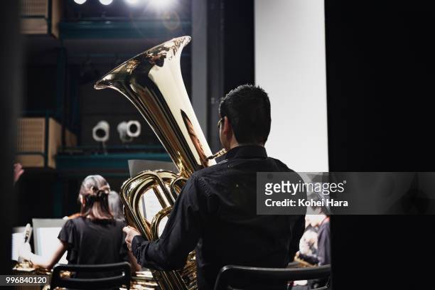 man playing a tuba at concert hall - klassieke orkestmuziek stockfoto's en -beelden