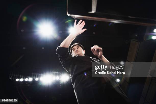 man conducting an orchestra at concert hall - classical orchestral music stock pictures, royalty-free photos & images