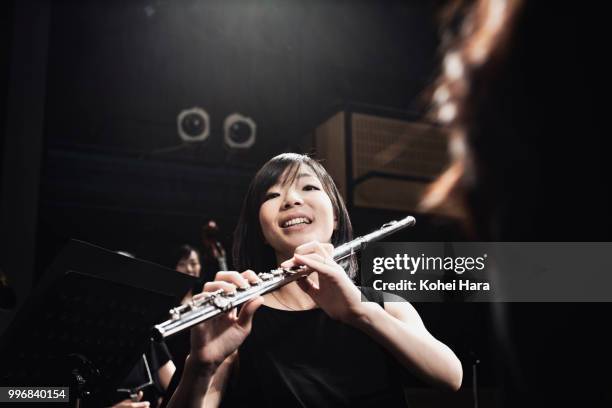 woman playing a flute at concert hall - orchestra pit stockfoto's en -beelden