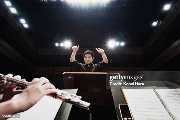 man conducting an orchestra at concert hall - orquestra imagens e fotografias de stock