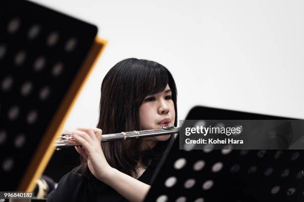 woman playing a flute at concert hall - classical orchestral music stock pictures, royalty-free photos & images