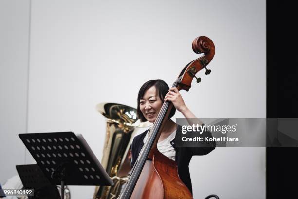 woman playing a contrabass at concert hall in rehearsal - instrumento-baixo imagens e fotografias de stock