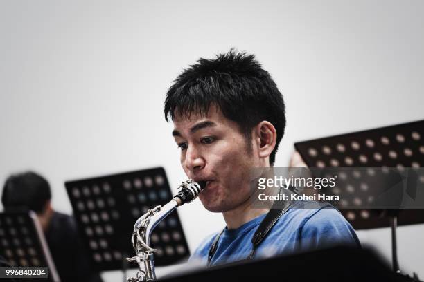 man playing an alto saxophone at concert hall in rehearsal - kohei hara foto e immagini stock