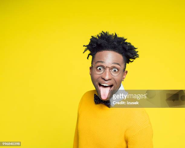 funny portrait of nerdy young man sticking out tongue - izusek stock pictures, royalty-free photos & images