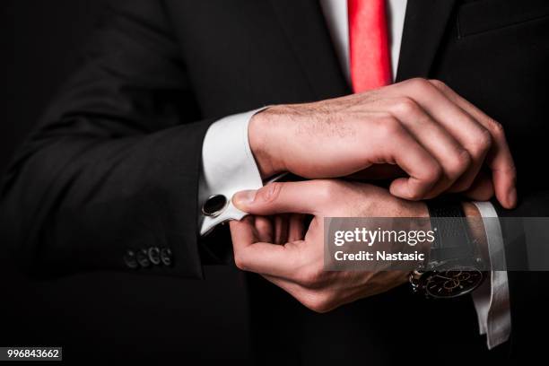 businessman fixing cuff links - sleeve stock pictures, royalty-free photos & images