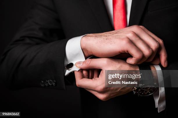 businessman fixing cuff links - cuff sleeve stock pictures, royalty-free photos & images