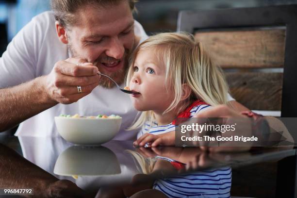 father feeding breakfast to cute little girl at table - sherman oaks fotografías e imágenes de stock