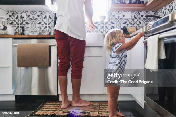 young daughter helping father in kitchen - sherman oaks fotografías e imágenes de stock