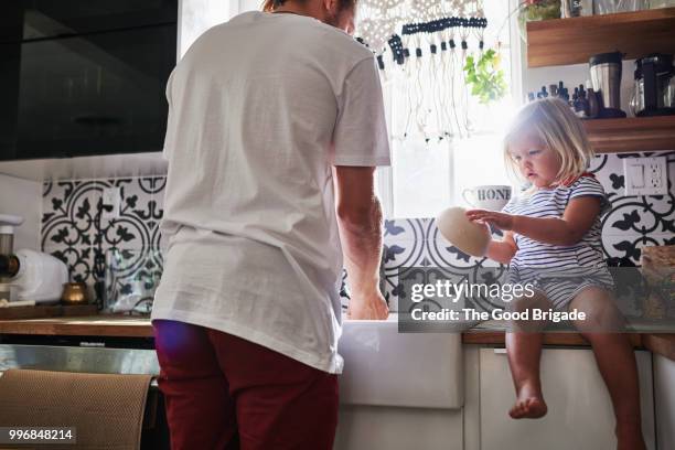 father and daughter washing dishes in kitchen at home - worktop stock pictures, royalty-free photos & images