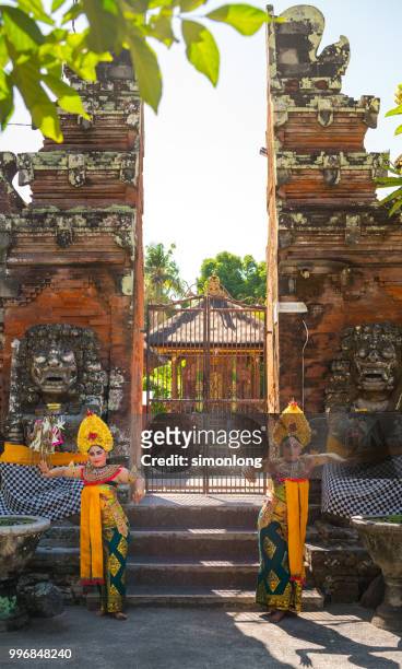 two balinese dancer dancing in front of the bali gate - balinese culture stock-fotos und bilder