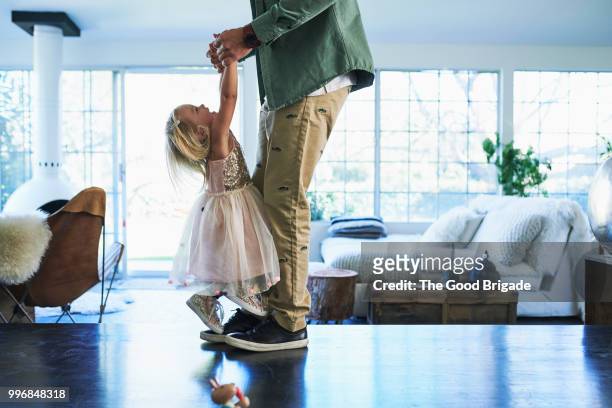 daughter standing on feet of father dancing - father daughter 個照片及圖片檔