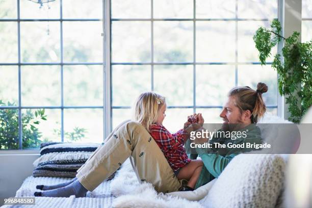 father and daughter playing on sofa at home - sherman oaks bildbanksfoton och bilder