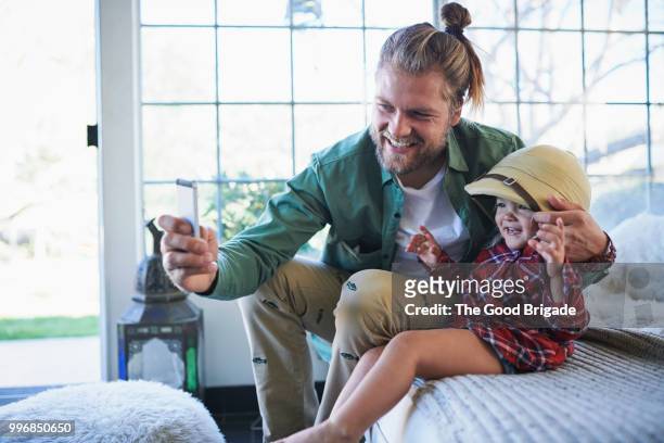 smiling father using mobile phone to take selfie with daughter - sherman oaks fotografías e imágenes de stock