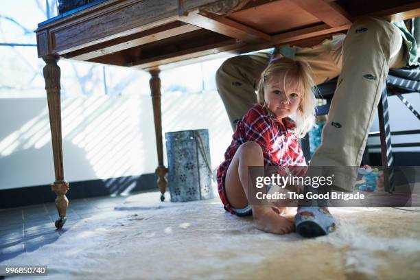 portrait of cute girl sitting under desk while father working - sherman oaks bildbanksfoton och bilder