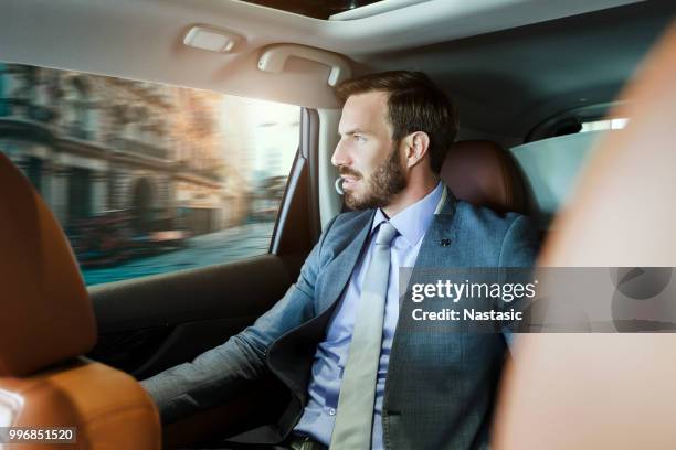 businessman driving through city - leather car interior stock pictures, royalty-free photos & images