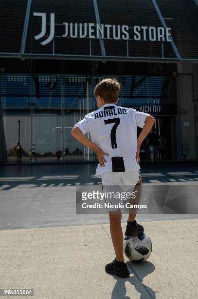 Supporter of Juventus FC poses with Cristiano Ronaldo's Juventus official jersey in front of Juventus Store. Juventus FC and Real Madrid CF announced...