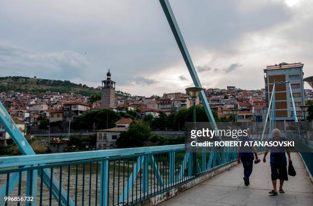 People walk on a bridge in the city of Veles on June 12, 2018.