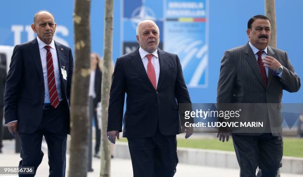 Iraqi Prime Minister Haider al-Abadi walks with officials including Iraq's Defence Minister Erfan al-Hiyali as he arrives for the second day of the...
