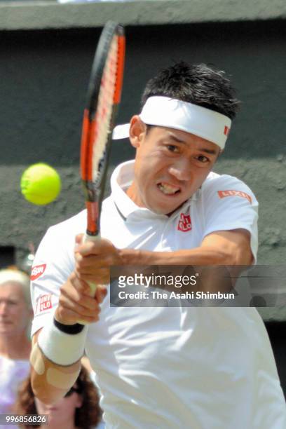 Kei Nishikori of Japan plays a backhand against Novak Djokovic of Serbia during their Men's Singles Quarter-Finals match on day nine of the Wimbledon...