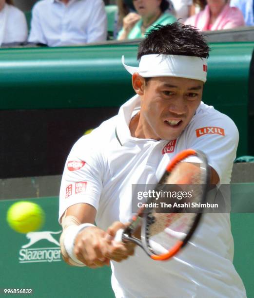 Kei Nishikori of Japan plays a backhand against Novak Djokovic of Serbia during their Men's Singles Quarter-Finals match on day nine of the Wimbledon...