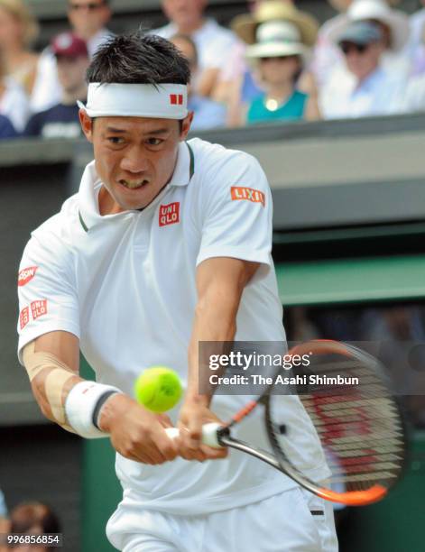 Kei Nishikori of Japan plays a backhand against Novak Djokovic of Serbia during their Men's Singles Quarter-Finals match on day nine of the Wimbledon...