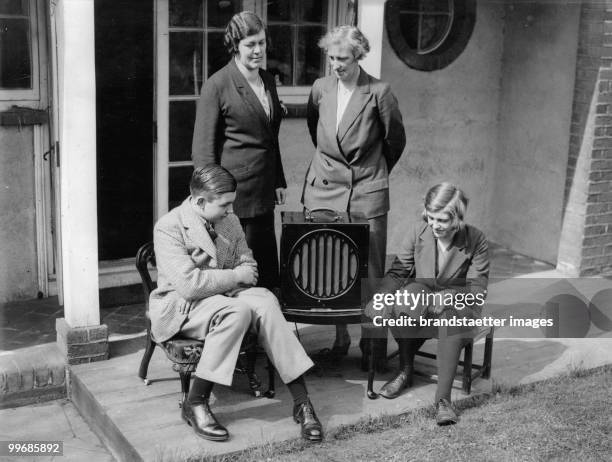 Family listening to a trial via radio. England. Photograph. Around 1930.