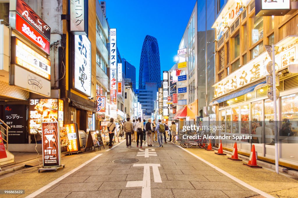 Street with shops and restaurants in Shinjuku district in Tokyo, Japan